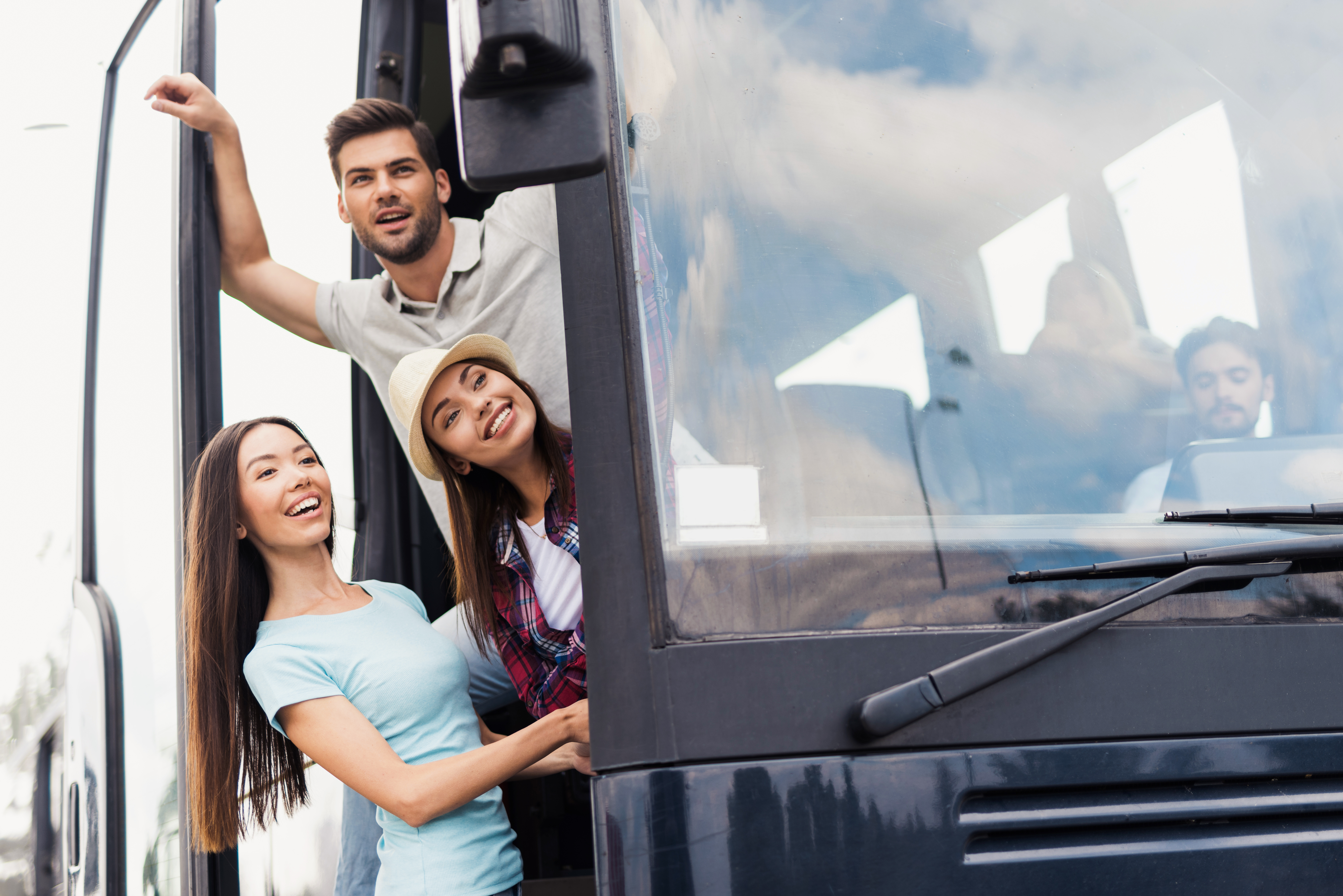 Jeunes gens devant un autocar de voyage. (Young people in front of a travel coach.)