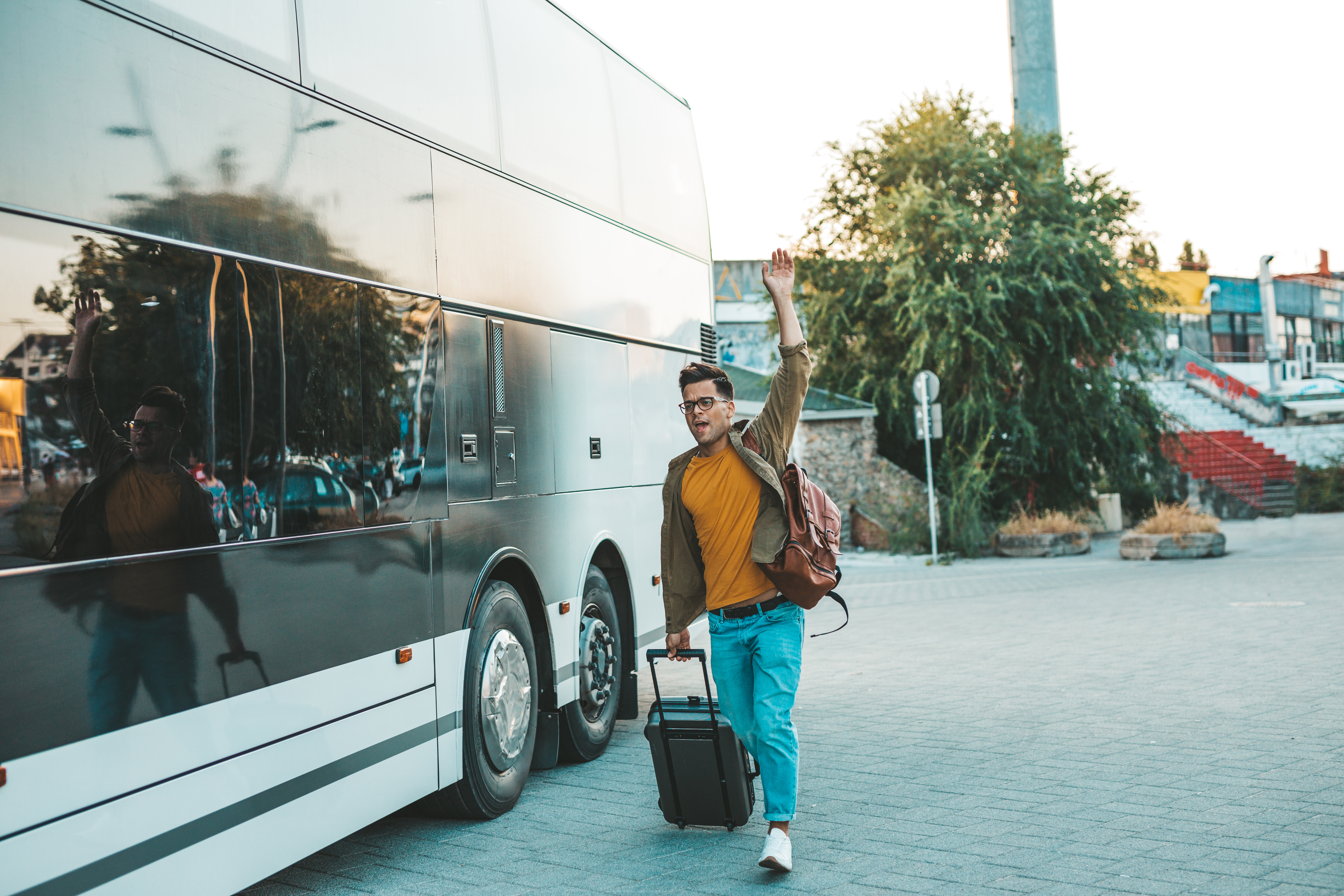 Un jeune homme court après le bus qui vient de partir. Il a raté son bus et essaie de le rattrape